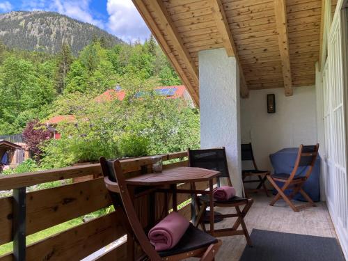 un patio avec une table et des chaises sur un balcon dans l'établissement Ferienwohnung / Appartement Bergliebe, à Garmisch-Partenkirchen