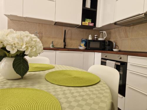a kitchen with a table with green plates and a vase of flowers at La Casa di Vale Muse in Trento