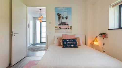 a bedroom with a large white bed with pillows at Villa Sea breeze in Bergen aan Zee