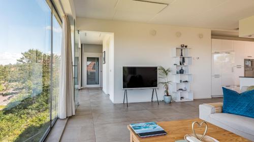 a living room with a couch and a television at Villa Sea breeze in Bergen aan Zee