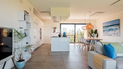 a kitchen and living room with a couch and a table at Villa Sea breeze in Bergen aan Zee