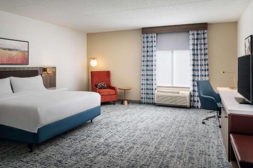 a hotel room with a bed and a chair at Hilton Garden Inn Huntsville South/Redstone Arsenal in Huntsville