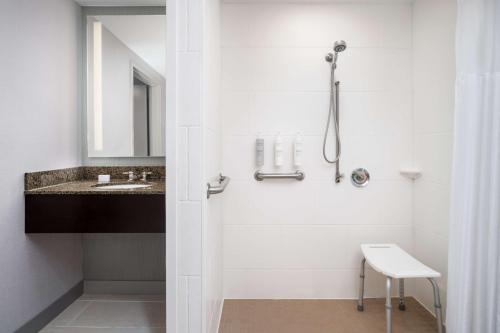 a white bathroom with a shower and a sink at Hilton Garden Inn Huntsville South/Redstone Arsenal in Huntsville