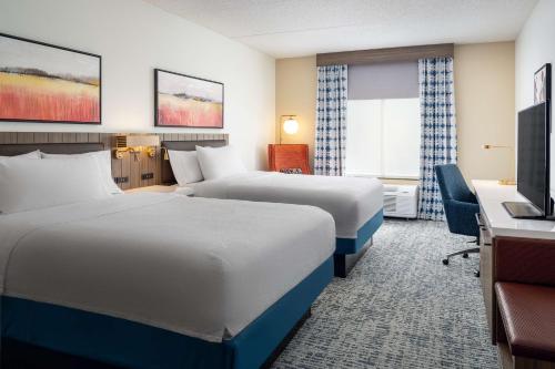 a hotel room with two beds and a desk at Hilton Garden Inn Huntsville South/Redstone Arsenal in Huntsville