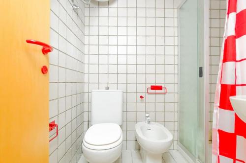 a white bathroom with a toilet and a sink at Villa Angelina - Mare Privato in Cannizzaro