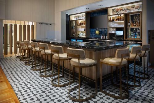 a bar with a row of stools in a restaurant at Hampton Inn & Suites Myrtle Beach Oceanfront in Myrtle Beach