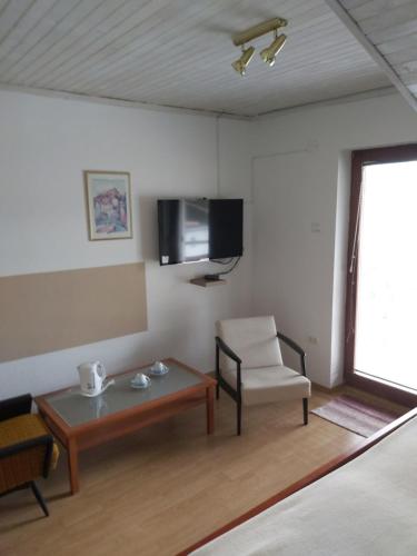a room with a table and a chair and a tv at Rooms Zagon in Postojna