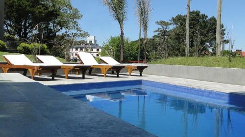 奧斯坦德的住宿－La Gavea，游泳池旁的一排躺椅