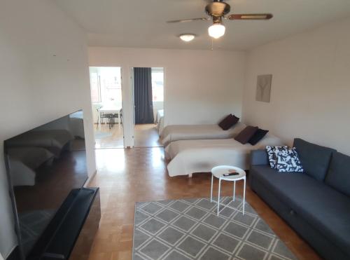 a living room with a couch and a table at Saunallinen tilava kaksio keskustan ja rautatieaseman tuntumassa in Hämeenlinna