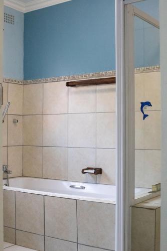 a bath tub in a bathroom with a shower at Utopia in Palm Beach in Port Edward