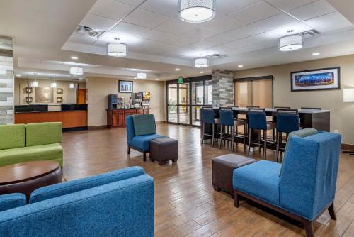 a waiting room with blue chairs and a bar at Comfort Inn Birmingham Homewood in Birmingham