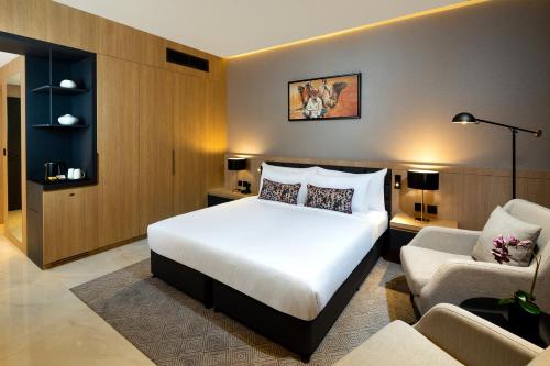 a bedroom with a bed and a couch and a chair at Millennium Place Mirdif in Dubai