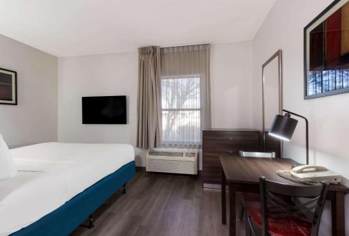 a hotel room with a bed and a desk and a computer at MainStay Suites Extended Stay Hotel Casa Grande in Casa Grande