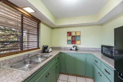 a kitchen with green cabinets and a sink at Quality Inn Payson in Payson