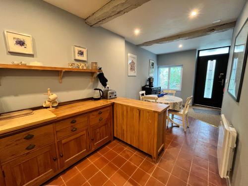 une cuisine avec des placards en bois et une salle à manger dans l'établissement Cute 2 bed cottage - Fources, Gascony, à Fourcès