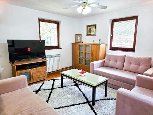 a living room with a couch and a tv at Sarajevo Pine Hideaway - Free Private Parking in Sarajevo