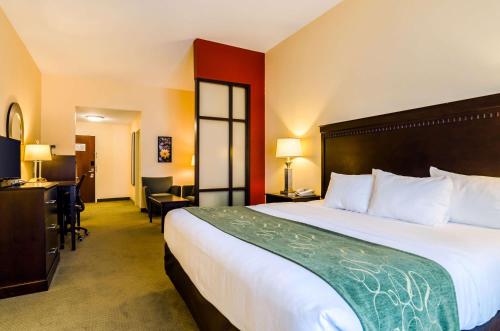 a hotel room with a large bed and a desk at Comfort Suites in Gothenburg