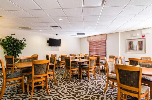 a dining room with tables and chairs and a tv at Comfort Suites in Gothenburg