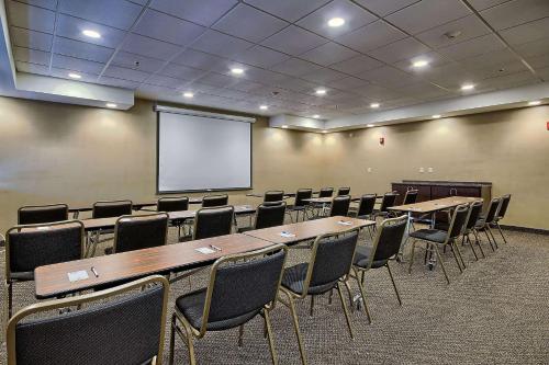 a conference room with tables and chairs and a screen at Comfort Inn & Suites Wadsworth in Wadsworth