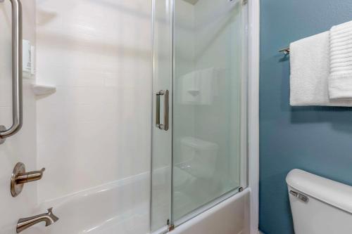 a shower with a glass door in a bathroom at Sleep Inn & Suites Norman near University in Norman