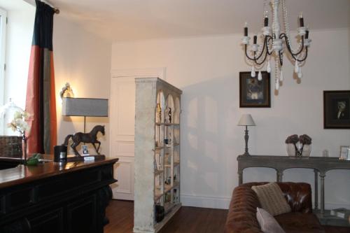 uma sala de estar com um sofá, uma mesa e uma estante de livros em Villa des Glycines em Thouars