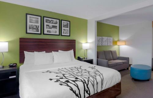 a hotel room with a bed and a chair at Sleep Inn & Suites near Fort Gregg-Adams in Riverdale