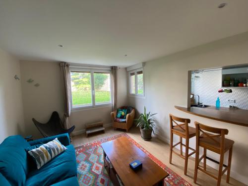un salon avec un canapé bleu et une table dans l'établissement Cosy apartment 10min from Paris Gare de Lyon, à Alfortville