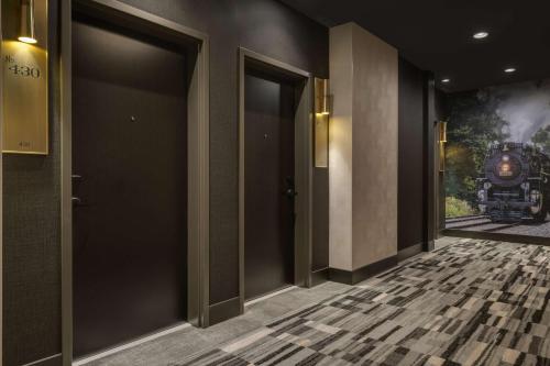 a hallway with doors with a train on the wall at Hotel Nickel Plate Fishers, Tapestry Collection By Hilton in Fishers