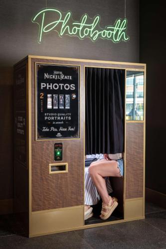 a person is sitting in an atm machine at Hotel Nickel Plate Fishers, Tapestry Collection By Hilton in Fishers