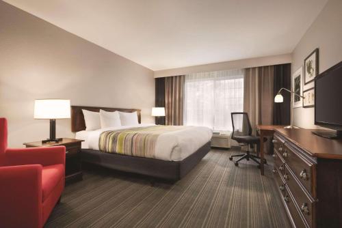 a hotel room with a bed and a desk at Country Inn & Suites by Radisson, Michigan City, IN in Michigan City