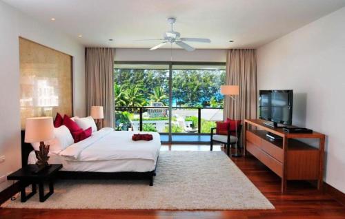 a bedroom with a bed and a flat screen tv at Pearl of Naithon in Nai Thon Beach