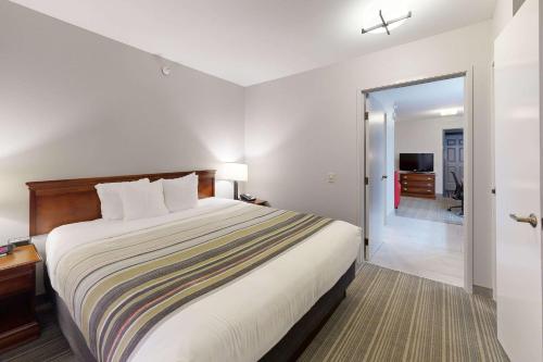 a hotel room with a bed and a sliding glass door at Country Inn & Suites by Radisson, Michigan City, IN in Michigan City