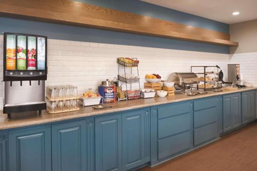 a kitchen with blue cabinets and a counter at Country Inn & Suites by Radisson, Michigan City, IN in Michigan City