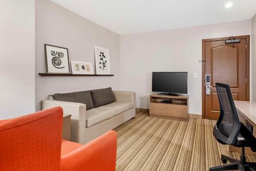 a living room with a couch and a flat screen tv at Country Inn & Suites by Radisson, Annapolis, MD in Annapolis