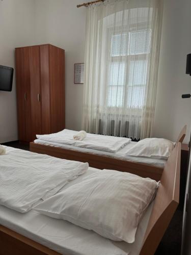 two beds in a room with a window at Guesthouse Pri Tonetu in Ptuj