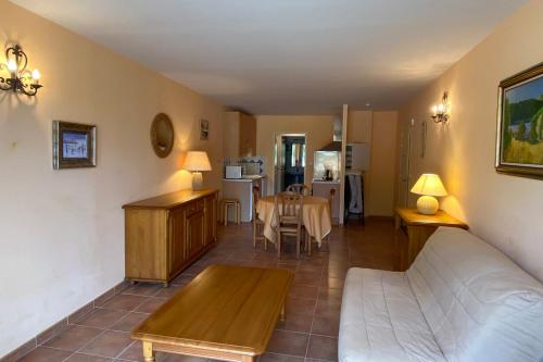 a living room with a couch and a table at 04B2 Beautiful studio in a mas provençal - pool in Brunet