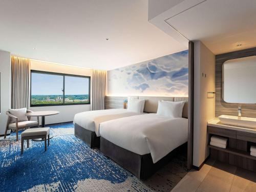 a hotel room with a large bed and a sink at Grand Mercure Ise-shima Resort & Spa in Shima