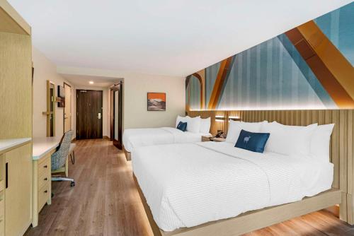 a hotel room with two beds and a desk at Cambria Hotel North Conway in North Conway