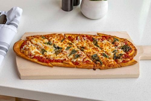 a pizza sitting on a cutting board on a table at Cambria Hotel North Conway in North Conway