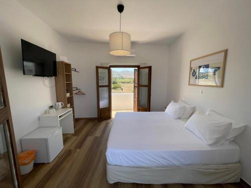 a bedroom with a white bed and a television at Kissamos Bay Hotel in Kissamos