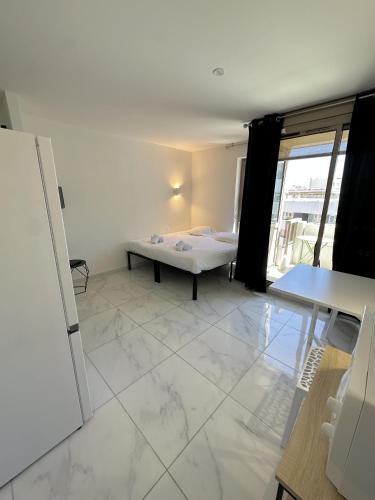 une chambre avec un lit et un grand sol carrelé dans l'établissement Résidence Graziella Studio 604, à Juan-les-Pins