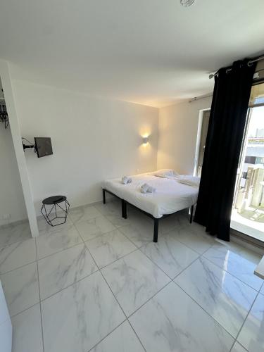 une chambre avec un lit dans une pièce avec une fenêtre dans l'établissement Résidence Graziella Studio 604, à Juan-les-Pins