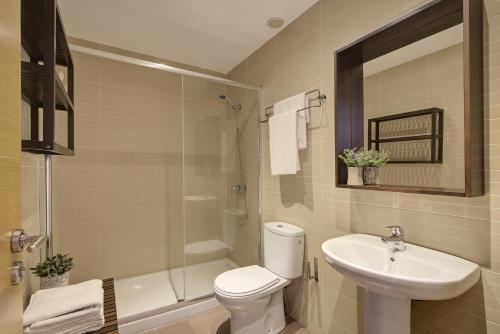 a bathroom with a toilet and a sink and a shower at Triana 2 in Melilla