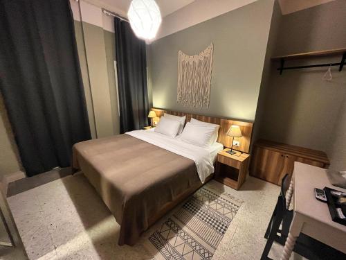 a bedroom with a large bed and a desk at Beit Mirna Guesthouse & Chalet - Ehden in Ehden
