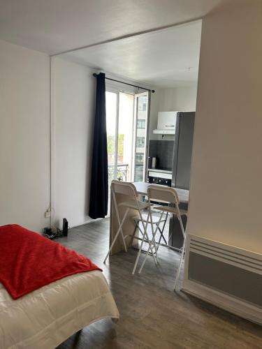 - une chambre avec une table et des chaises dans l'établissement Studio très lumineux et équipée en pleine avenue !, au Kremlin-Bicêtre