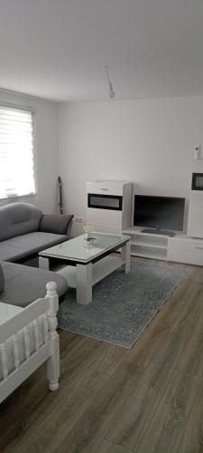 Una sala de estar con un sofá y una mesa de café. en DADA apartman, en Keze