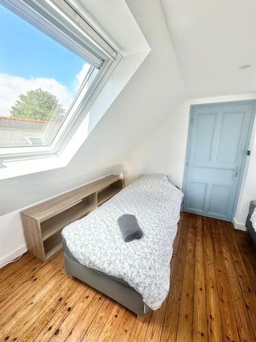 a bedroom with a bed in a room with a window at Maison de vacances Audierne centre avec terrasse proche des plages in Audierne