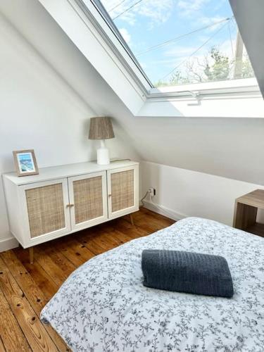 a bedroom with a bed and a large window at Maison de vacances Audierne centre avec terrasse proche des plages in Audierne