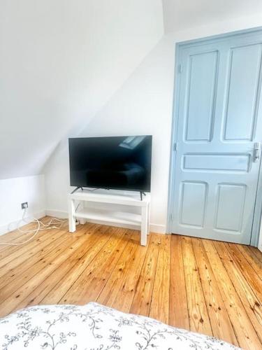 a room with a flat screen tv and a door at Maison de vacances Audierne centre avec terrasse proche des plages in Audierne