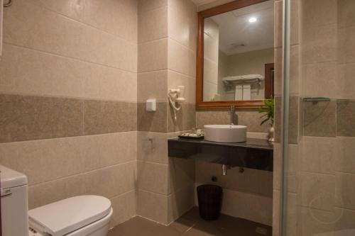 a bathroom with a toilet and a sink and a mirror at Glorious Hotel in Kompong Thom